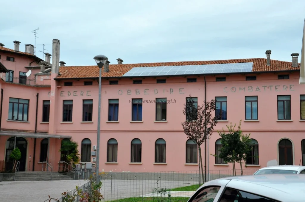 Fotografia storica di una scritta murale di epoca fascista su un edificio a Palmanova, in provincia di Udine.
